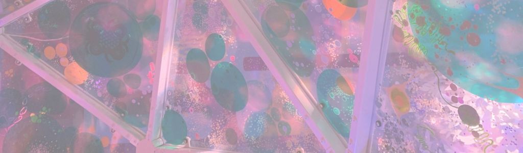 Interior of a colorful igloo-like structure at Meow Wolf Dallas, covered in bright, bubble-like forms and metallic surfaces.